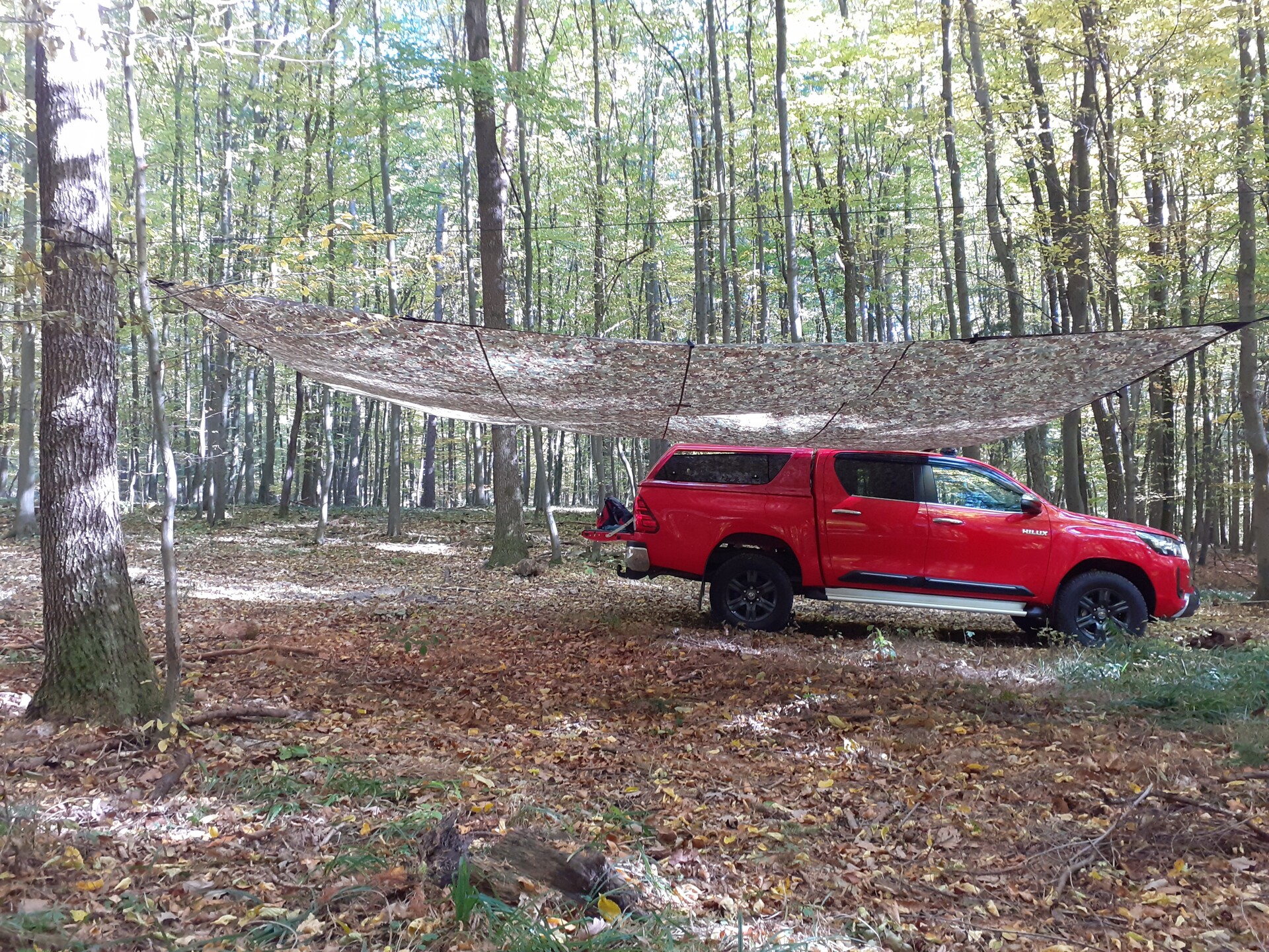 Bivakovací plachta DD Hammocks 5x5m uvázaná na auto